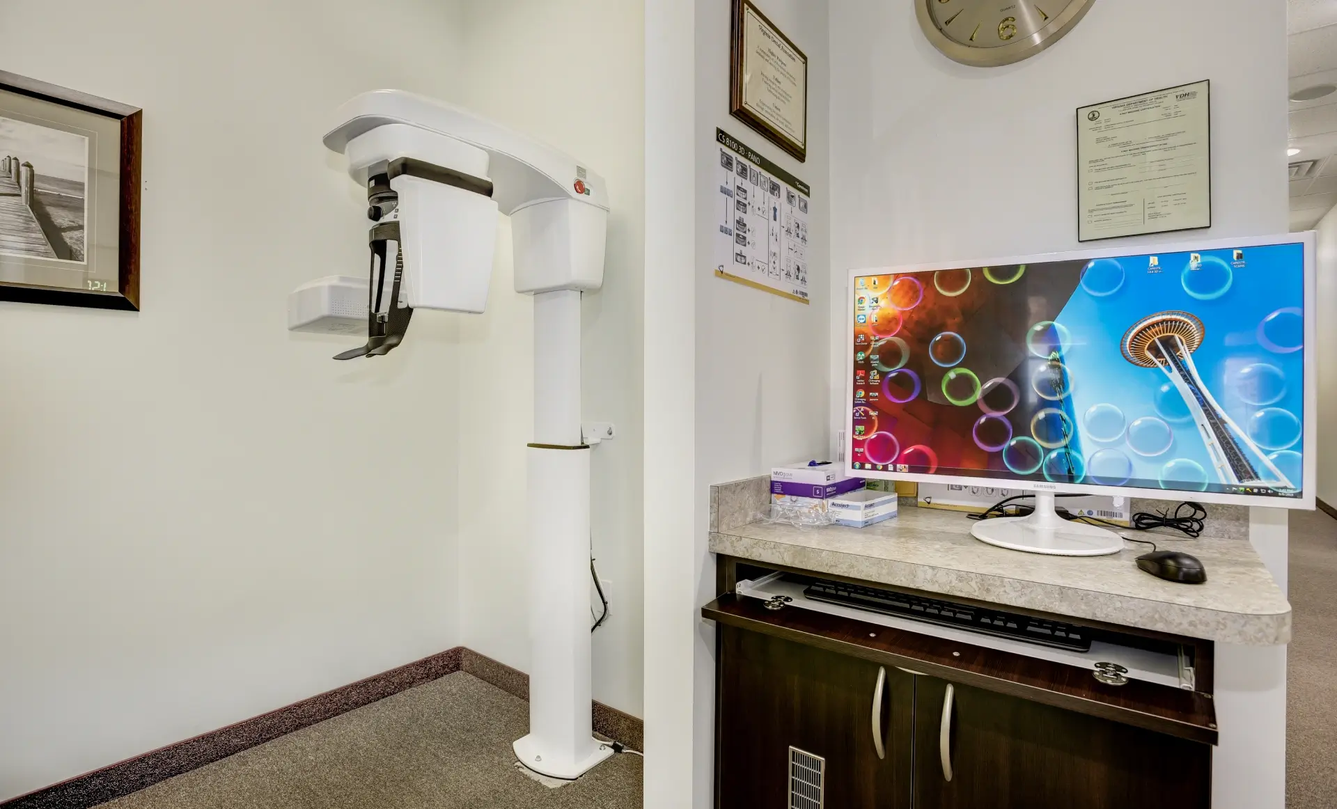 Medical device in a clinical room beside a counter with a colorful screen.